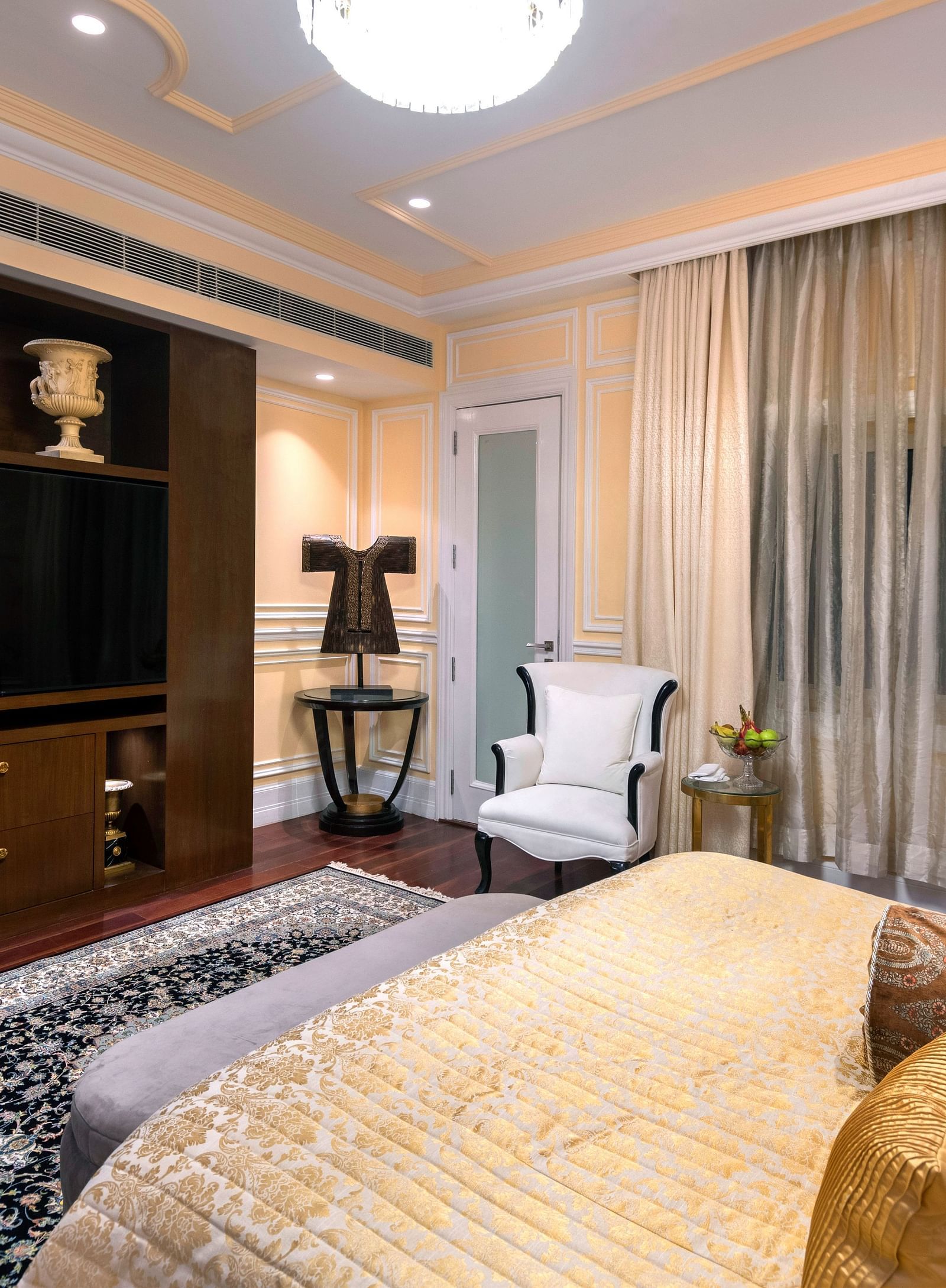 Prestige room with bed and a television in front of the bed at The Claridges, New Delhi