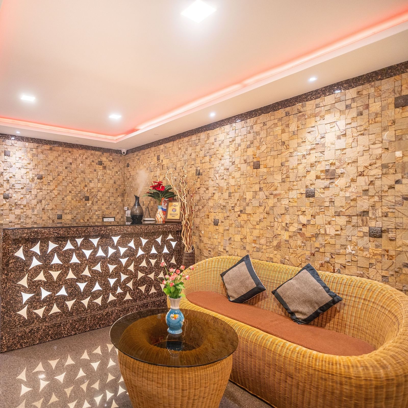 A reception area with a sofa and a table in front at Parampara Residency, Kushalnagar.