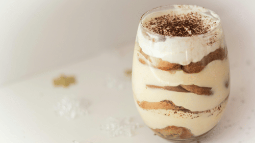 Layered pudding with biscuit and cream on a glass. 