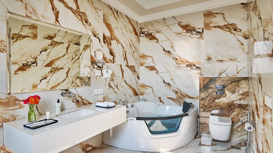 a water closet, a hot tub, and the vanity area in the restroom of the PREMIER ROOM - Royal Kingdom Sarovar Portico, Pilibhit