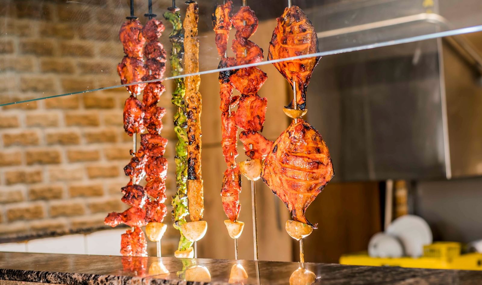 Skewered food cooking on a grill at The Citi Residenci Hotel, Durgapur.
