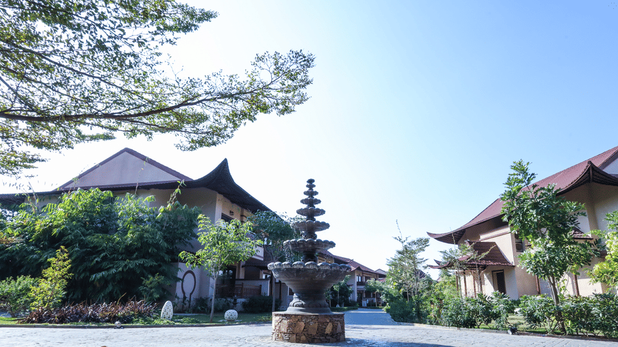 An open courtyard area with buildings, plants and a central installation at Ananta Spa and Resort, Jaipur