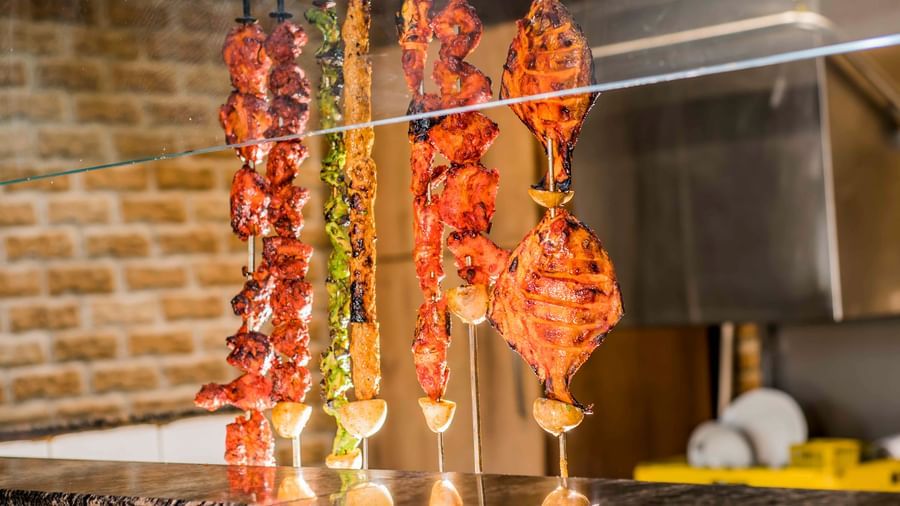 Skewered food cooking on a grill at The Citi Residenci Hotel, Durgapur.