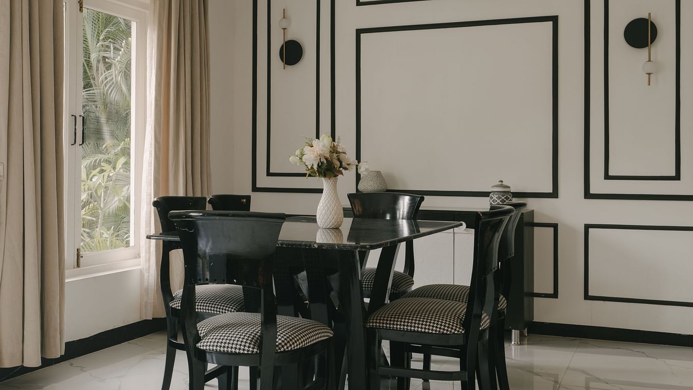 Elegant dining area with black-and-white panelled walls in Three BHK Premium Villa, Richmonde Ananta Elite, Goa.