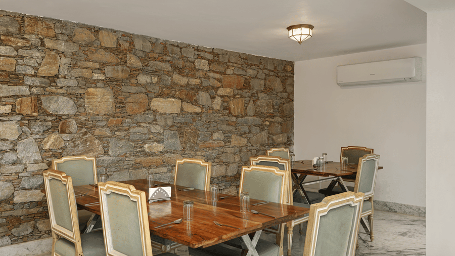 Restaurant of Fatehs Safari Suites, Kumbhalgarh featuring dining chairs and tables.