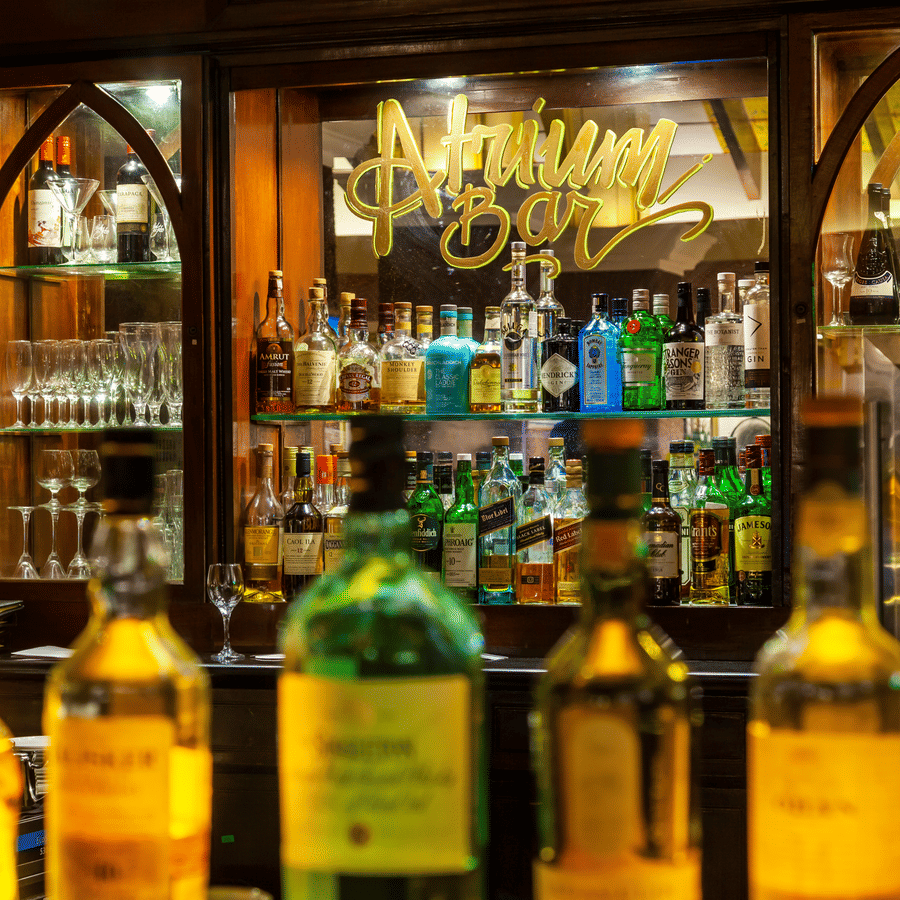 overview of the bar counter with the showcase filled with drinks in view - Caravela Beach Resort Goa