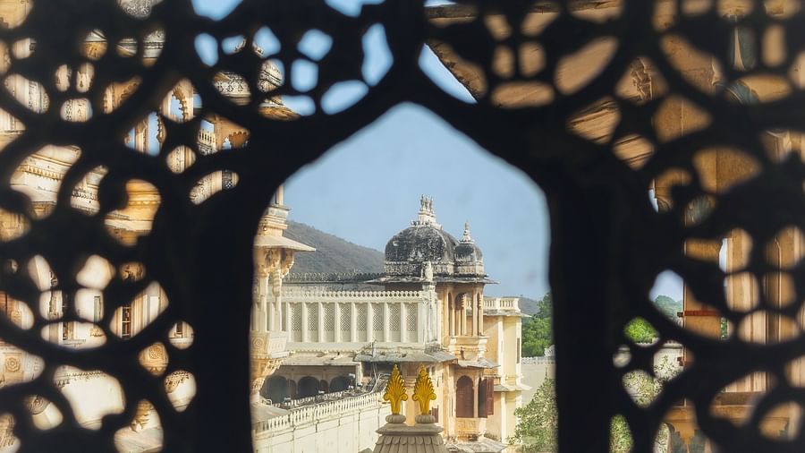 A view via a well carved lattice window of an elaborate edifice