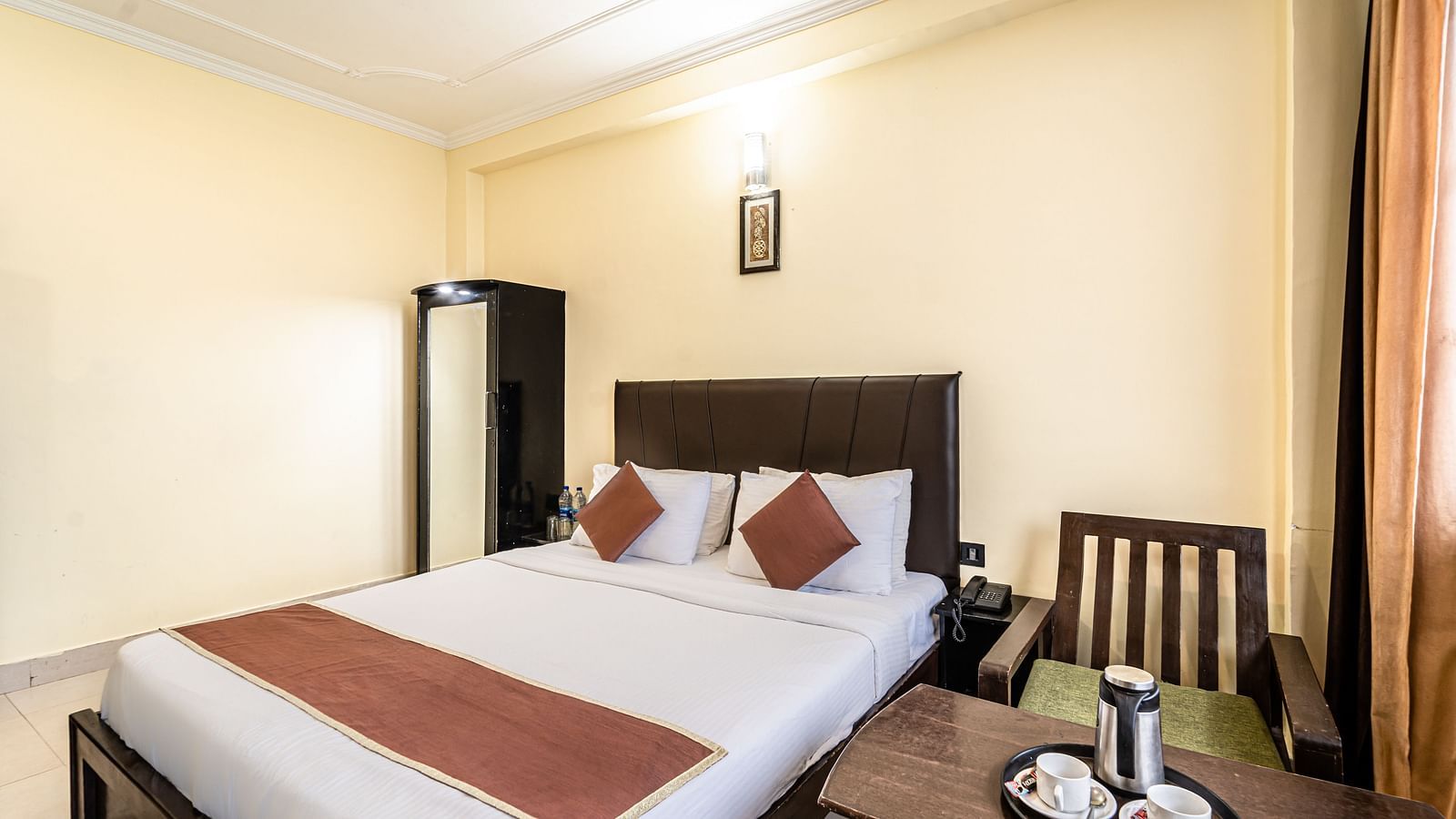 a bedroom at Flutter Hotels & Resorts featuring a bed, a working desk and a wardrobe