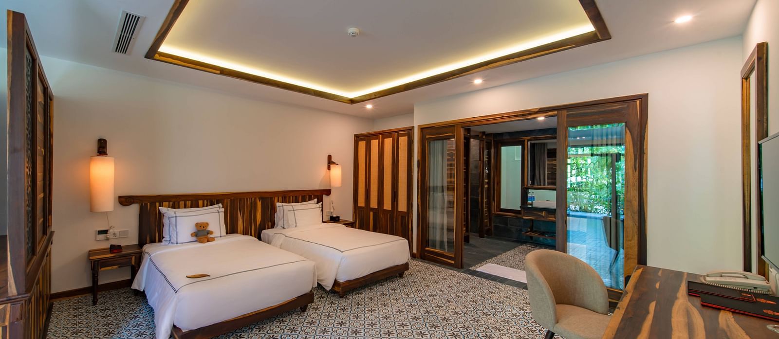 A hotel room with ceiling mounted lights, twin beds comfortable furniture - Alibu Resort Nha Trnag