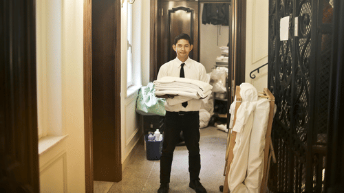 A person holding neatly folded clothes