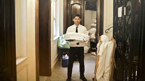 A person holding neatly folded clothes