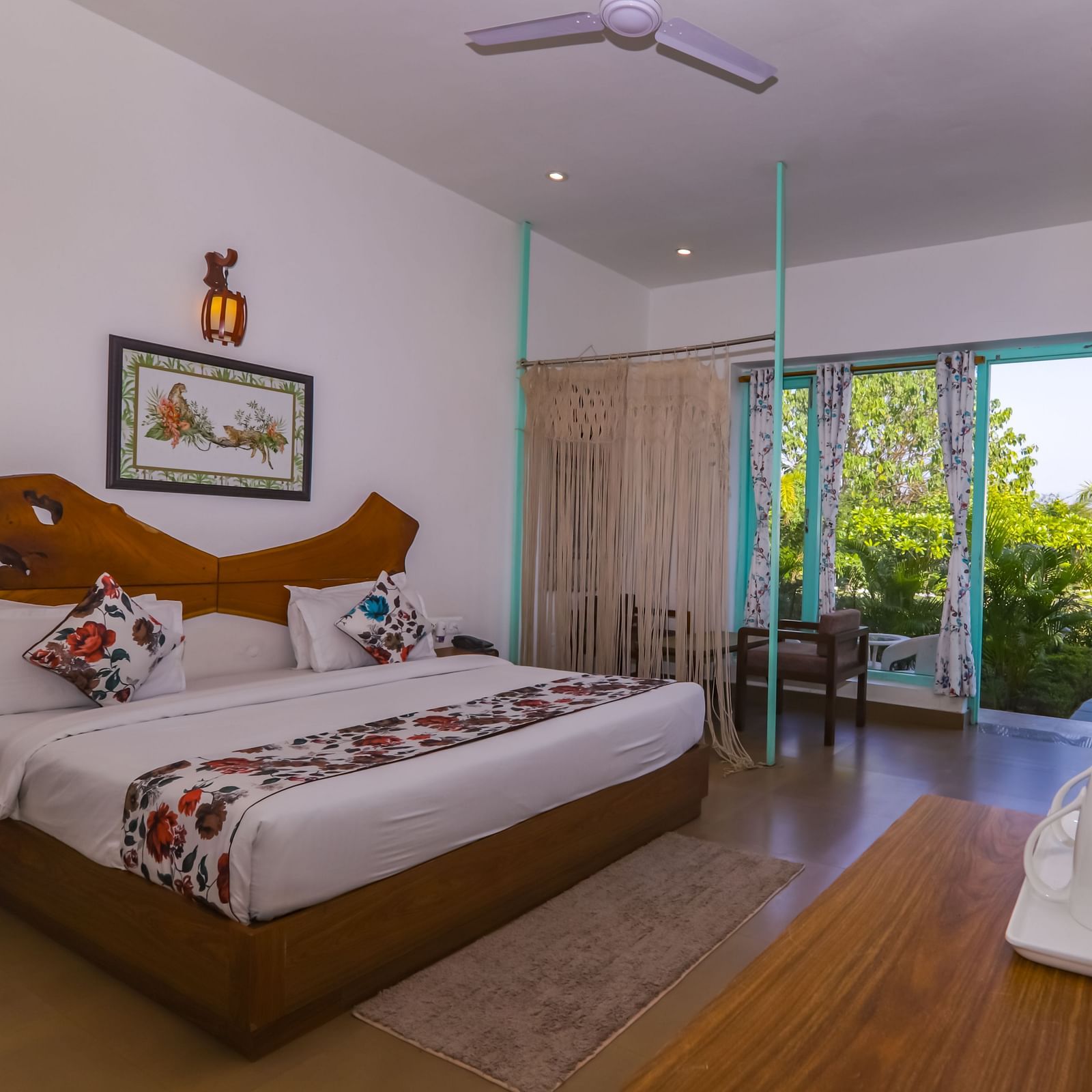 Spacious bedroom at Vedikant Resorts The Mallard Corbett with two beds, open curtains, and outdoor greenery visible through the sliding glass door.