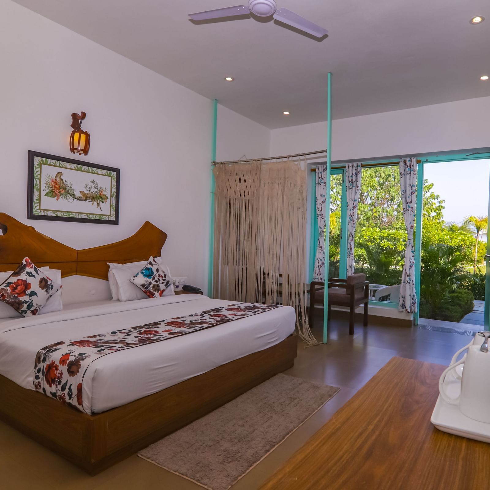Spacious bedroom at Vedikant Resorts The Mallard Corbett with two beds, open curtains, and outdoor greenery visible through the sliding glass door.