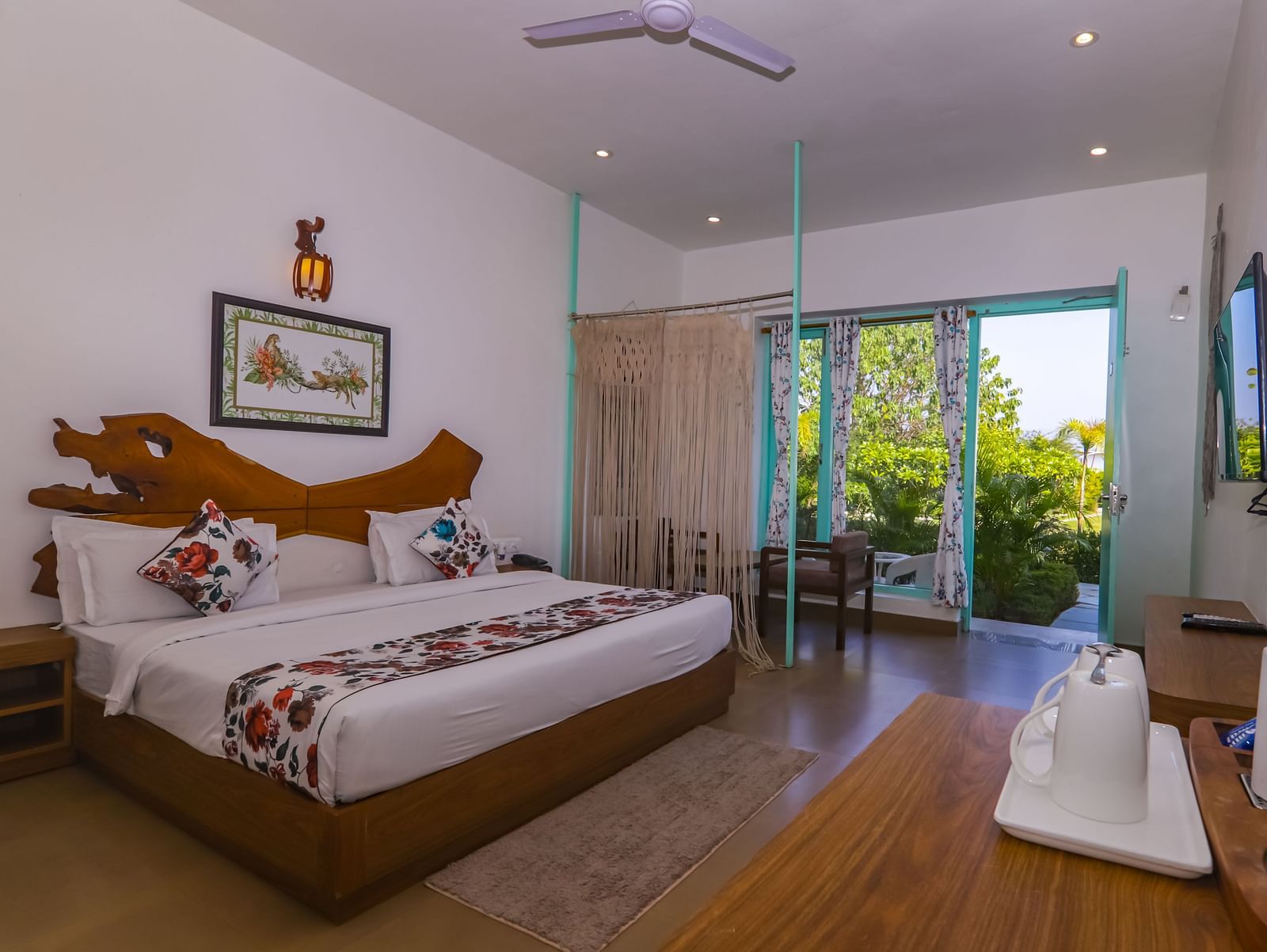 Spacious bedroom at Vedikant Resorts The Mallard Corbett with two beds, open curtains, and outdoor greenery visible through the sliding glass door.