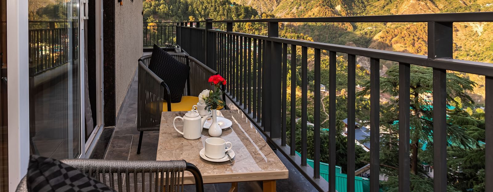 Balcony with outdoor seating overlooking mountains.
