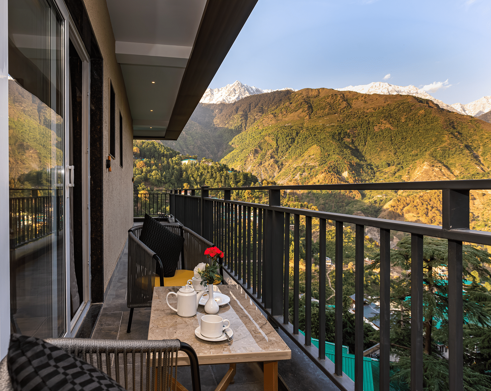 An image of a balcony attached to a Suite which has chairs and table overlooking the mountains - The Belvedere Himalayan Retreat, McLeodganj