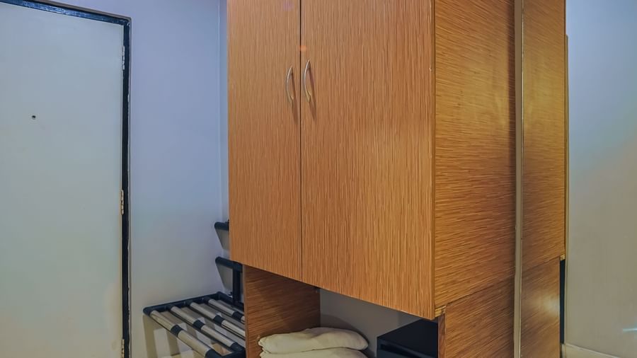 Wooden wardrobe with storage shelves and mini fridge at Max Hotel Prayagraj.
