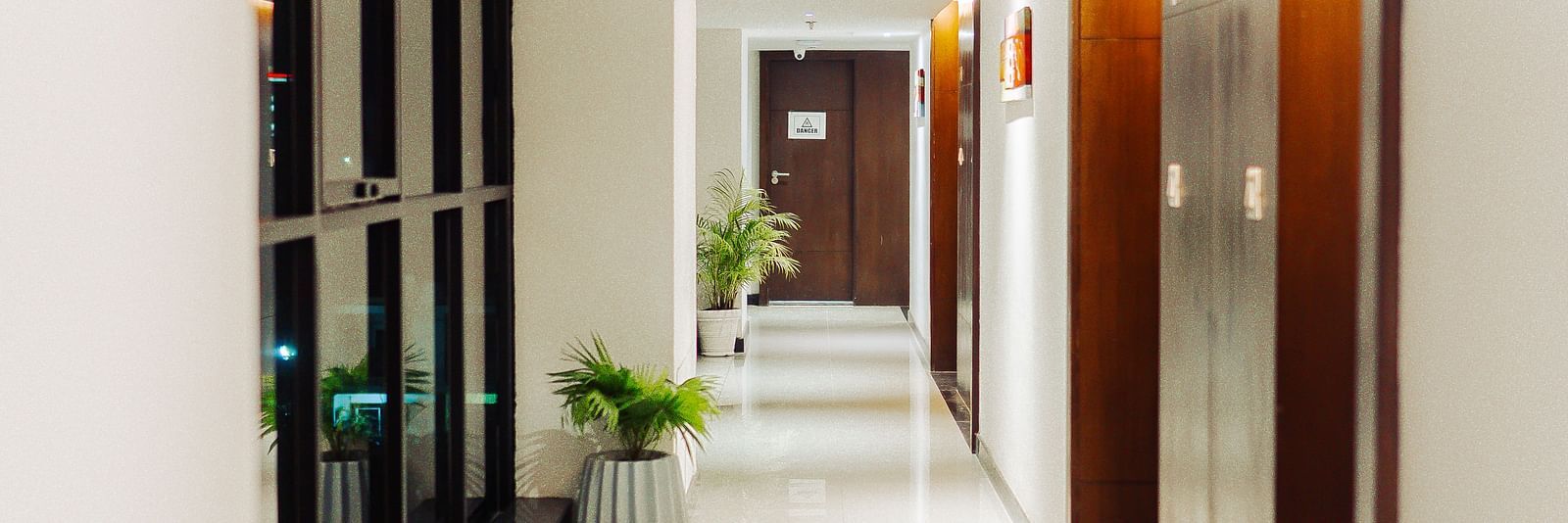 a passage with windows on one end and doors on the other - Jardin Hotels