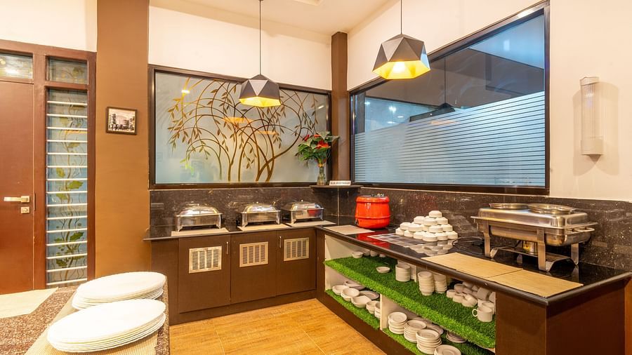 A cupboard with crockery in it and dishes on top at Parampara Resort & Spa, Kushalnagar.