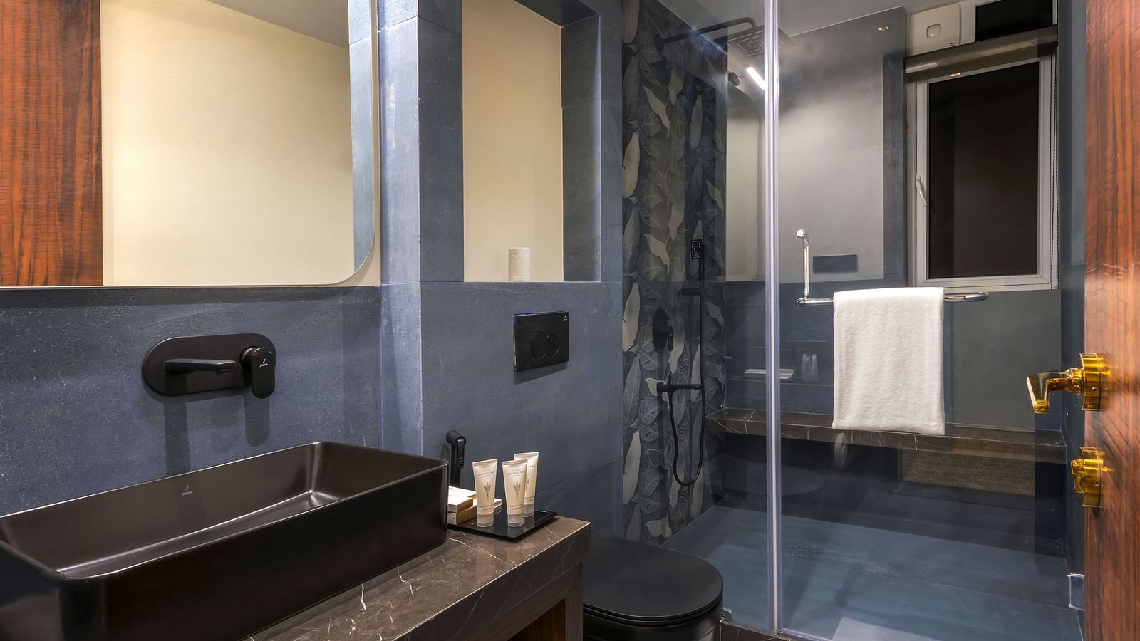 An overview of a bathroom with shower area in view in one of the rooms - The Tanisi Hotels & Resorts, Goa