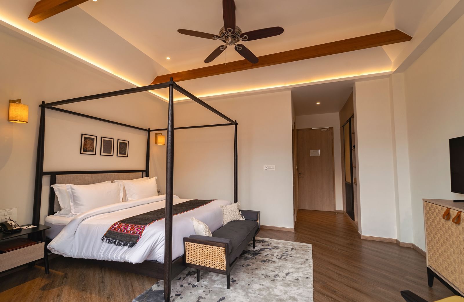 Bedroom with a four-poster bed, rug, and open doorway at Nivasana Manali.