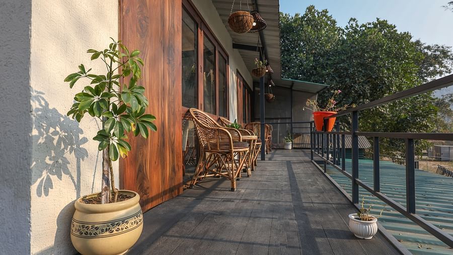 The balcony with chairs facing the view of River View Room at the Sylvan Retreat, Dehradun.