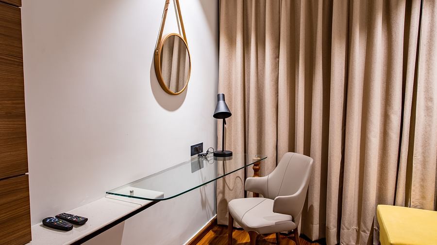 the study table with a mirror on the wall inside one of the rooms - Wedlock Greens Hotel Resorts Dhanbad