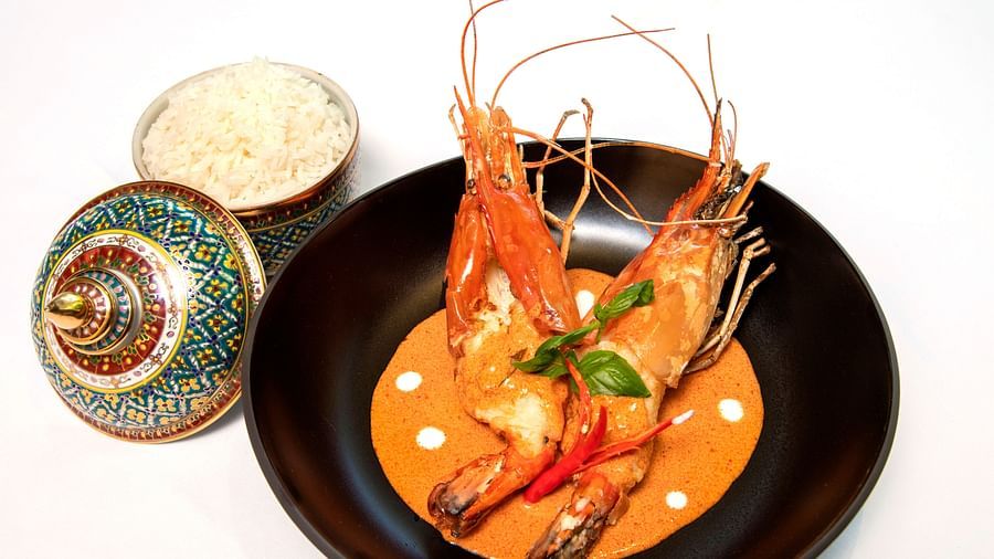Thai-style prawn curry with jasmine rice, elegantly served in a black bowl with a traditional decorative lid