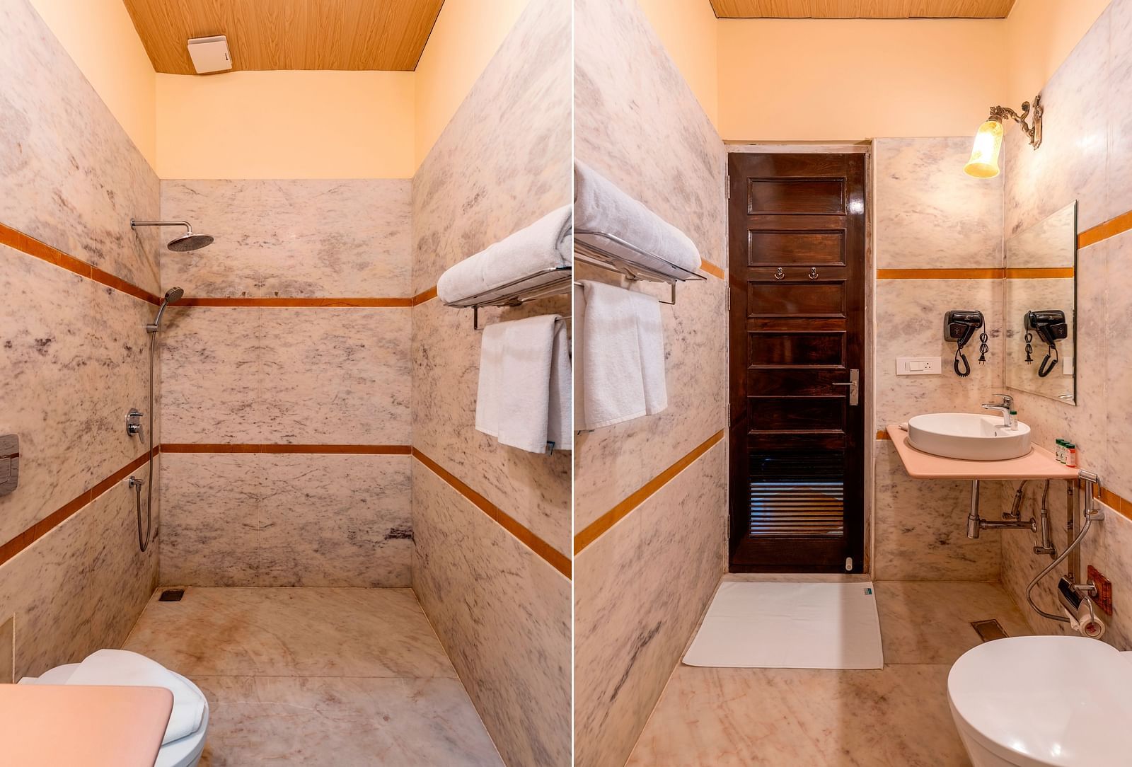 Modern bathroom with marble walls, walk-in shower, and twin mirrors at Kesar Bagh Palace.