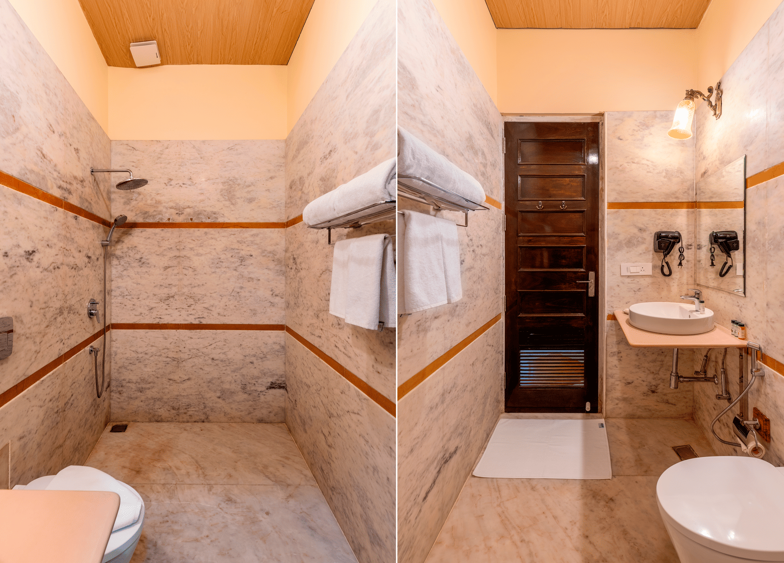 Modern bathroom with marble walls, walk-in shower, and twin mirrors at Kesar Bagh Palace.