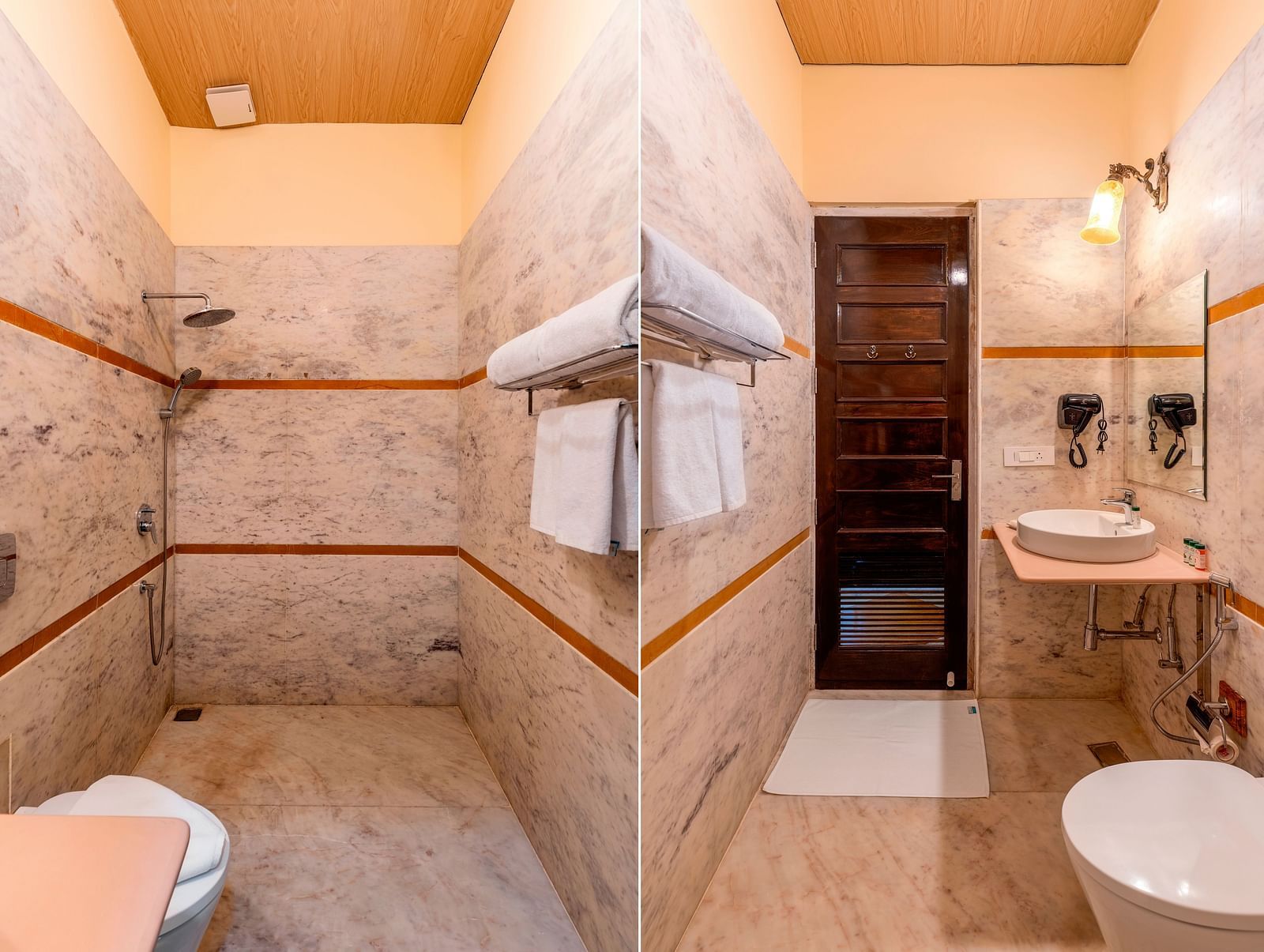 Modern bathroom with marble walls, walk-in shower, and twin mirrors at Kesar Bagh Palace.