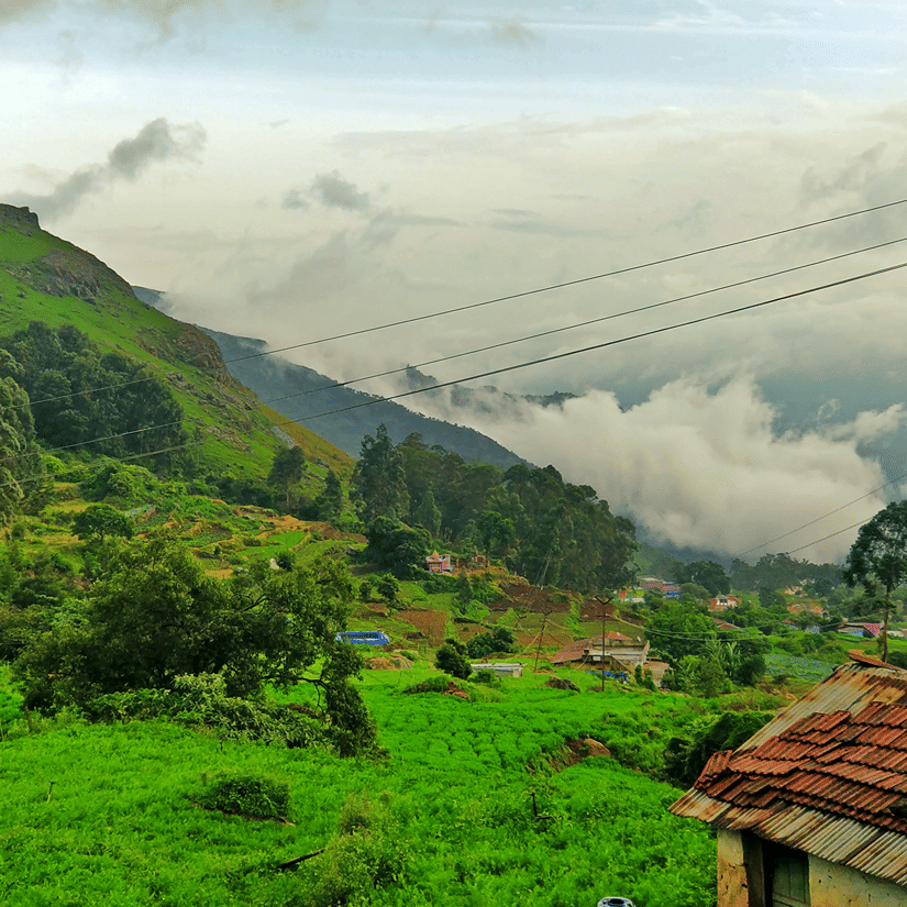 An overview of a mountain with a hut surrounded by greenery.