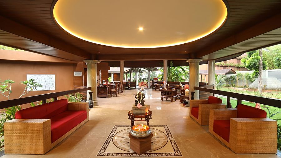 The lobby area of Uday Backwater Resort, showcasing elegant sofa sets and a reception desk in the background, bathed in natural daylight