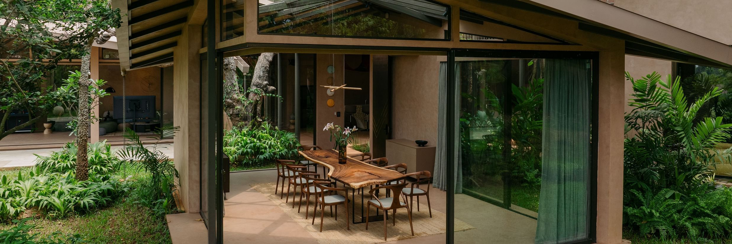 Glass-walled dining pavilion surrounded by lush greenery at Villa Moira Goa.