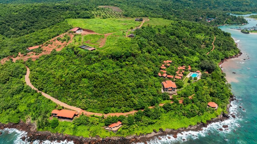 An aerial view of our resort along a crescent-shaped coastline - Highland Sarovar Portico, Sindhudurg