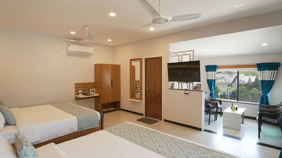 A room featuring two large beds, a TV and well lit ambience - MGM Whispering Wind's Resorts