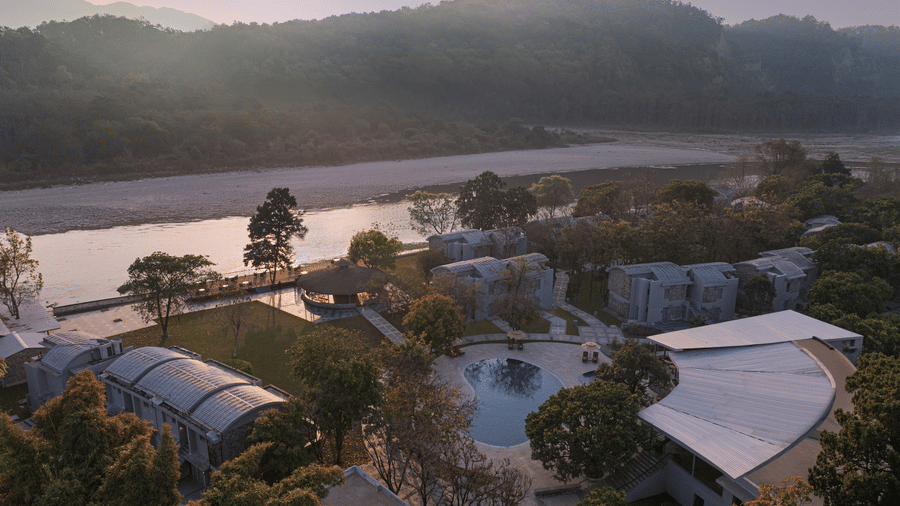 Aerial view of the resort surrounded by lush greenery and river landscape at The Corbett Hideaway.