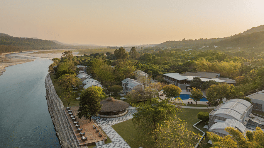Panoramic view of the river flowing alongside the resort with lush greenery at The Corbett Hideaway.