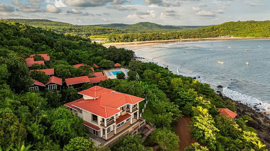 An image showcasing a resort by the side of the sea covered in lush green trees on all sides - Highland Sarovar Portico, Sindhudurg