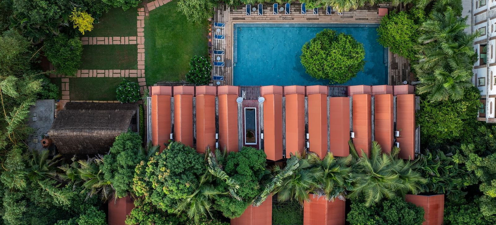 Top view of villas with swimming pool surrounded by trees