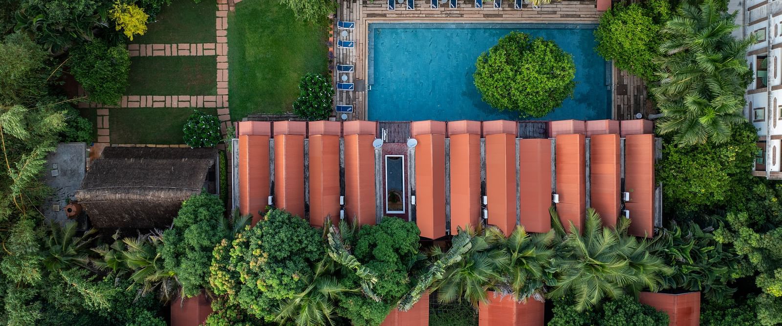 Top view of villas with swimming pool surrounded by trees