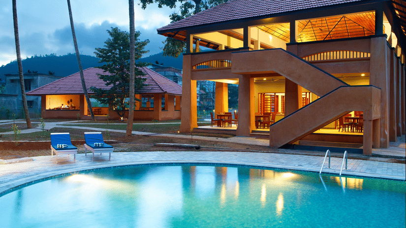 An overview of the swimming pool next to a building and loungers - Abad Green Forest, Thekkady.
