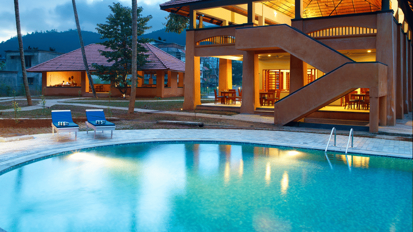 An overview of the swimming pool next to a building and loungers - Abad Green Forest, Thekkady.