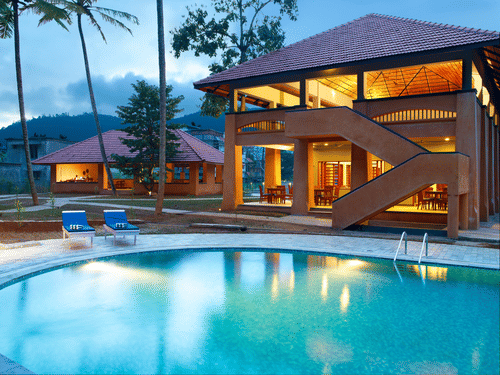 An overview of the swimming pool next to a building and loungers - Abad Green Forest, Thekkady.