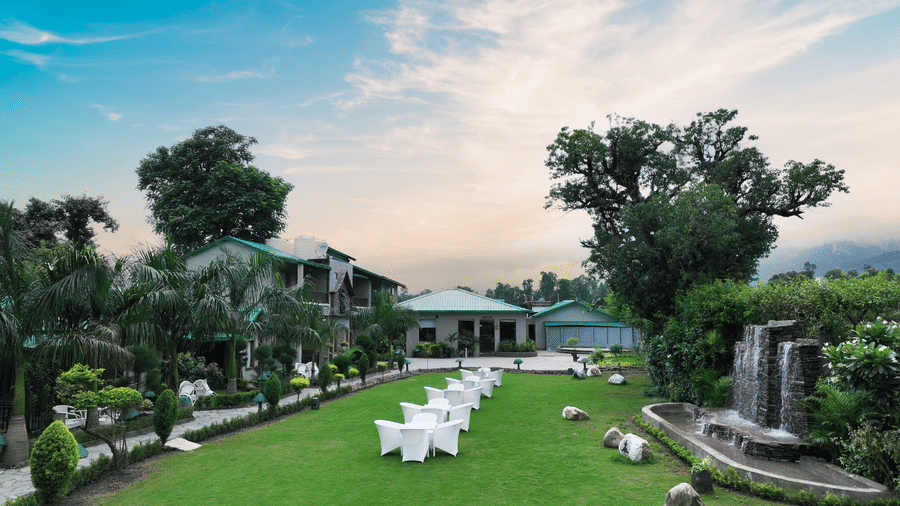 A wide-angle shot of he Lawn 2 at Corbett Nirvana Resort with a beautiful blue sky in the background.