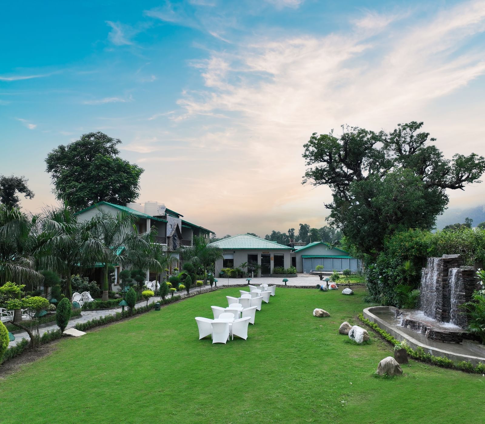 A wide-angle shot of he Lawn 2 at Corbett Nirvana Resort with a beautiful blue sky in the background.