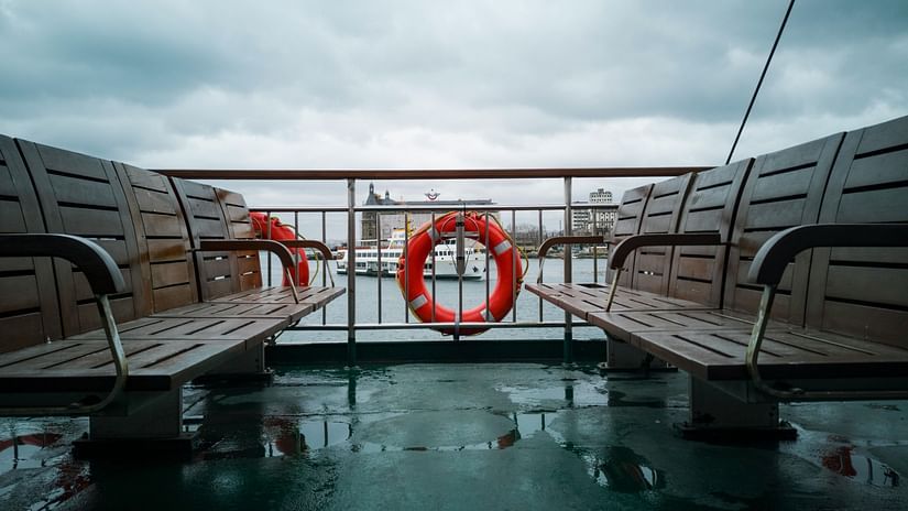 Two brown benches placed opposite to each other in a ferry.