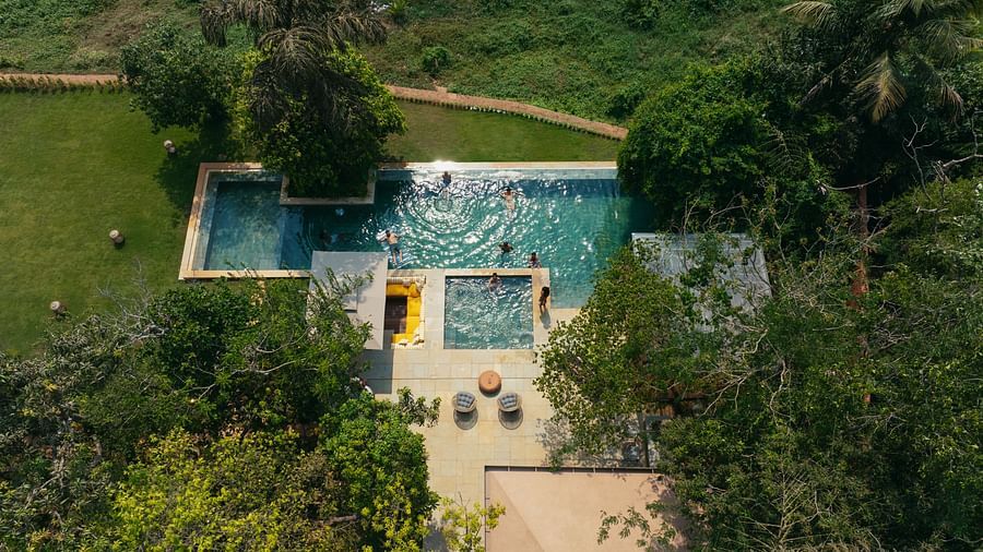 An aerial perspective of Villa Moira by V Escapes, revealing multiple interconnected pools and a clear pathway, all set within a verdant landscape.