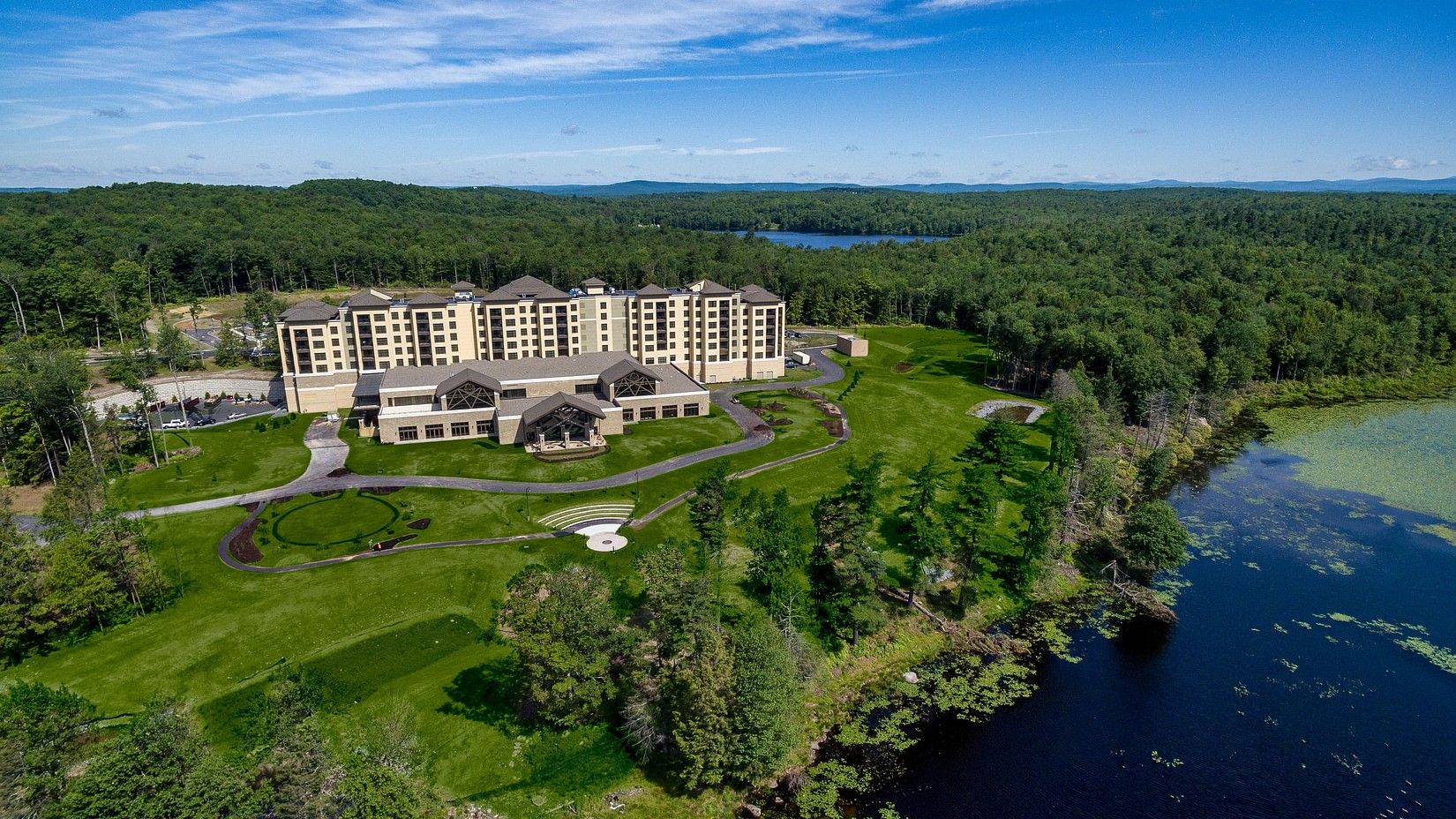 Aerial view of  YO1 Health Resort, Catskills, New York surrounded by lush greenery and a lake