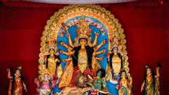 A large and vibrant Durga Puja idol, showing the goddess Durga with ten arms slaying a demon. She is surrounded by her children: Lakshmi, Saraswati, Ganesha, and Kartikeya.